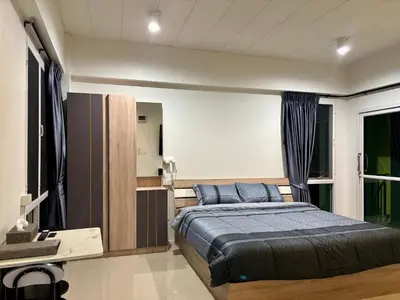 a bedroom with a bed and a desk and a window at โรงพักบางระมาด by ModiCoff Café in Sathani Ban Chim Phali