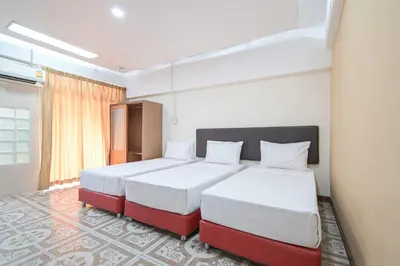 a bedroom with two beds with white and red at AC Habitat Bangkok in Bangkok
