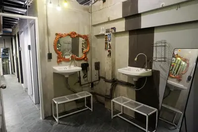 a bathroom with two sinks and a mirror on the wall at Silom Soi 3 Hash Hostel in Bangkok