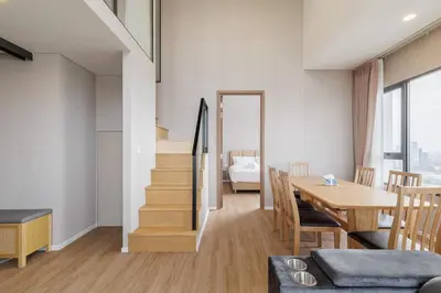 a living room with a dining room table and a staircase at loft \u6cf3\u6c60\u516c\u5bd3 \u4e09\u623f\u4e8c\u536b \u514d\u8d39WiFi in Bangkok