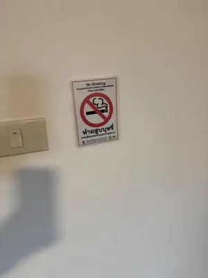 a no smoking sign on a wall in a room at ณัฐพิมลเพลส์ 3 in Bangkok Yai