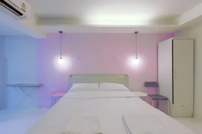 a bedroom with a white bed and pink walls at 24 degree hotel & hostels in Bangkok