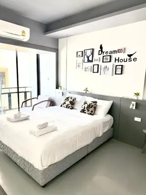 a bedroom with a large bed with white sheets at 24 degree hotel & hostels in Bangkok