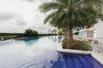 a swimming pool with a palm tree and flowers at \u66fc\u8c37\u7e41\u534e\u5730\u533a\u516c\u5bd3 \u514d\u8d39\u4e0a\u7f51 \u5bb6\u5c45\u5bb6\u7535\u9f50\u5168 in Bangkok