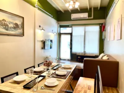 a dining room with a long wooden table and chairs at Entire house,Unwind in the city, near GrandPalace in Bangkok