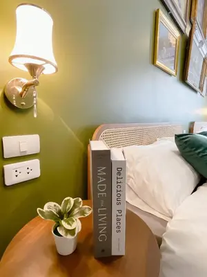 a book on a table next to a bed at Entire house,Unwind in the city, near GrandPalace in Bangkok