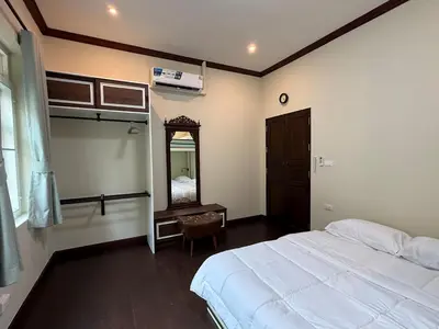 a bedroom with a large bed and a mirror at Luan Heritage Surawong in Bangkok