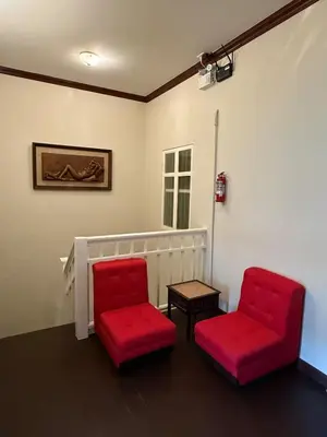 two red chairs and a table in a room at Luan Heritage Surawong in Bangkok