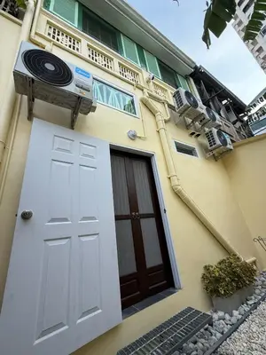a house with a white door and a balcony at Luan Heritage Surawong in Bangkok