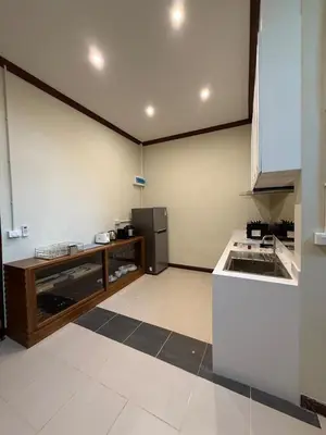 a small kitchen with a refrigerator and a counter at Luan Heritage Surawong in Bangkok