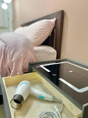 a glass table with a machine on it next to a bed at La Maison 230 in Ban Khlong Samrong
