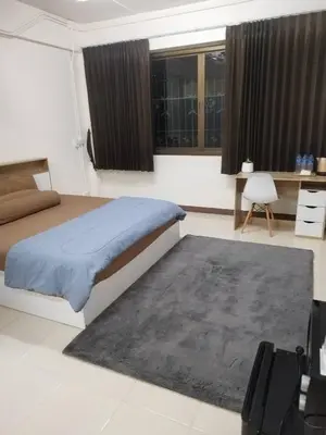 a bedroom with a bed and a rug and windows at Homey Place in Ban Song Hong