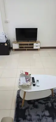 a living room with a coffee table and a tv at Homey Place in Ban Song Hong