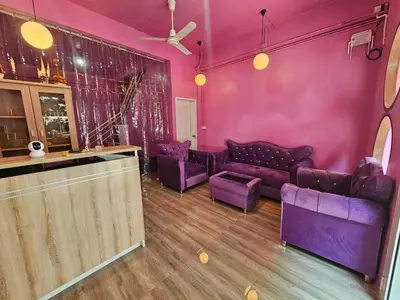 a living room with purple couches and a bar at Hostel In The City in Pom Prap