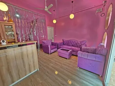 a purple living room with purple couches and a bar at Hostel In The City in Pom Prap