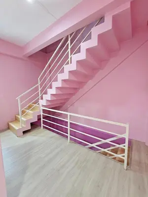 a staircase in a room with pink walls at Hostel In The City in Pom Prap