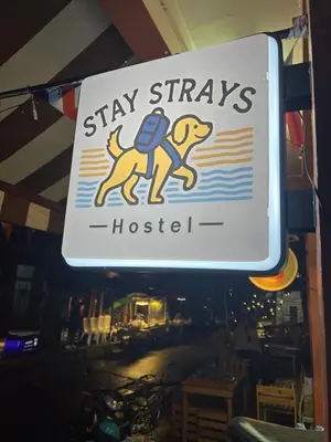 a sign for a stay stays hotsetter in a restaurant at Stay Strays Hostel in Bangkok