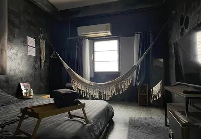 a bedroom with a hammock hanging from a window at Stay Strays Hostel in Bangkok