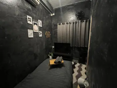 a bedroom with a bed and a table with a book at Stay Strays Hostel in Bangkok