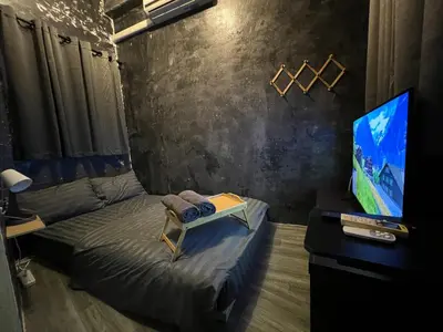 a room with a bed and a flat screen tv at Stay Strays Hostel in Bangkok