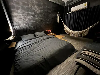 a bedroom with a bed and a hammock in it at Stay Strays Hostel in Bangkok