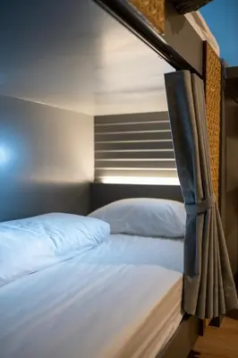 a bedroom with a bed with white sheets at The Chedee Krungthep in Bangkok