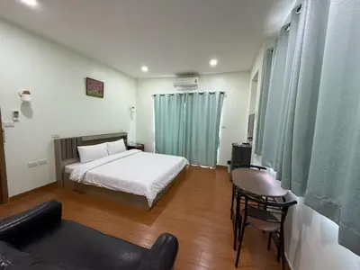 a bedroom with a bed and a couch and chairs at The Burapa Rooms in Bangkok