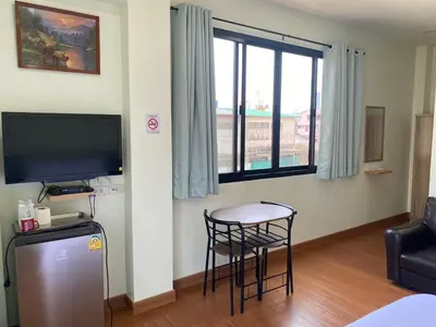 a living room with a small table and a television at The Burapa Rooms in Bangkok