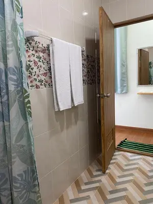 a bathroom with a shower and a glass door at The Burapa Rooms in Bangkok