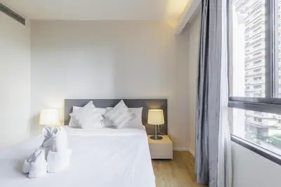 a white bedroom with a white bed and a window at 2 Bedrooms, Downtown BKK, BTSAsok, Sukhumvit in Bangkok