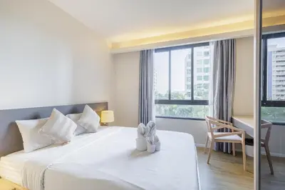a bedroom with a bed and a desk and a window at 2 Bedrooms, Downtown BKK, BTSAsok, Sukhumvit in Bangkok