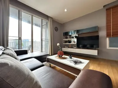 a living room with a couch and a tv at Roomy Modern 2BR - Ultra Fast WiFi - BTS Phrom Phong in Bangkok