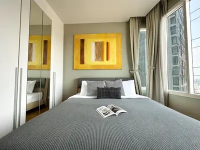 a bedroom with a bed with two books on it at Roomy Modern 2BR - Ultra Fast WiFi - BTS Phrom Phong in Bangkok
