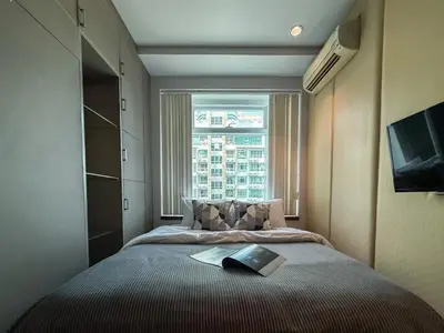 a bedroom with a large bed with a window at Luxurious High-Rise - Ultra Fast Wifi - MRT Petchaburi in Bangkok