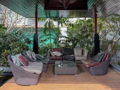 a porch with chairs and a table and plants at Luxurious High-Rise - Ultra Fast Wifi - MRT Petchaburi in Bangkok