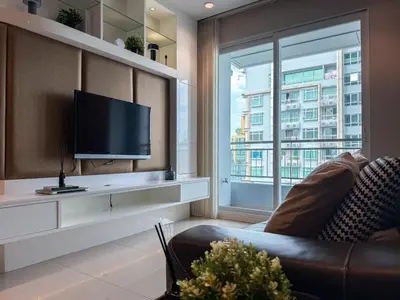 a living room with a tv and a couch and a window at Luxurious High-Rise - Ultra Fast Wifi - MRT Petchaburi in Bangkok