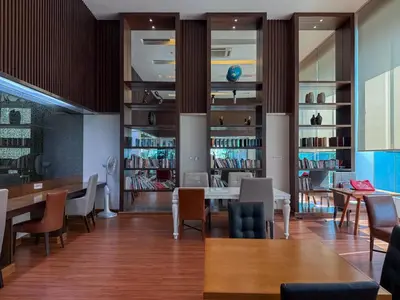 a dining room with tables and chairs and bookshelves at Luxurious High-Rise - Ultra Fast Wifi - MRT Petchaburi in Bangkok