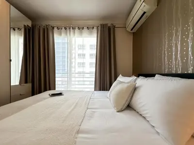 a bedroom with a large white bed with a window at Upscale Expansive 2BR - Ultra Fast Wifi - Phrom Phong in Bangkok
