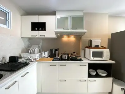 a kitchen with white cabinets and a microwave at Upscale Expansive 2BR - Ultra Fast Wifi - Phrom Phong in Bangkok