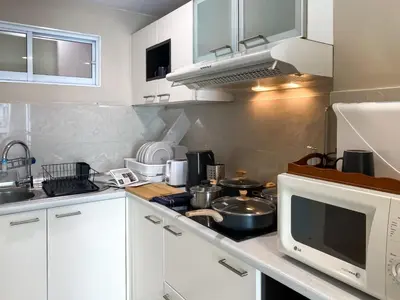 a kitchen with white cabinets and a microwave at Upscale Expansive 2BR - Ultra Fast Wifi - Phrom Phong in Bangkok