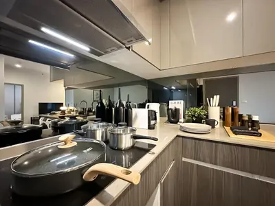 a kitchen with a stove with a pot and pans at Expansive Stylish 2BR - Ultra Fast Wifi - Asoke in Bangkok