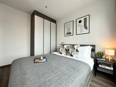 a bedroom with a bed with a book on it at Expansive Stylish 2BR - Ultra Fast Wifi - Asoke in Bangkok