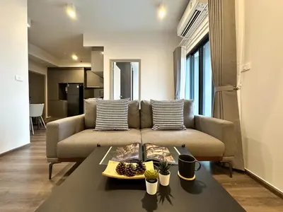a living room with a couch and a table at Expansive Stylish 2BR - Ultra Fast Wifi - Asoke in Bangkok