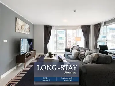 a living room with a long stay sign on the couch at Exclusive Urban Apt 1BR - Ultra Fast Wifi - Thong Lo in Bangkok