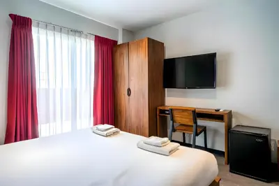 a hotel room with a bed and a desk and a television at XX GO INN Sukhumvit Soi 20 - โกอิน สุขุมวิท 20 BTS อโศก in Bang Kapi