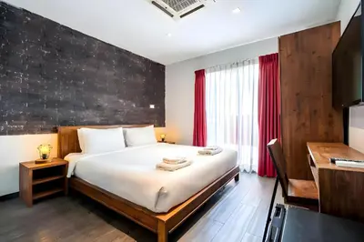 a bedroom with a large bed and a desk at XX GO INN Sukhumvit Soi 20 - โกอิน สุขุมวิท 20 BTS อโศก in Bang Kapi
