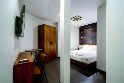 a bedroom with a bed and a desk with a desk at XX GO INN Sukhumvit Soi 20 - โกอิน สุขุมวิท 20 BTS อโศก in Bang Kapi