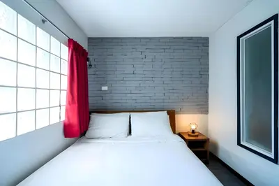 a bedroom with a bed with a red window at XX GO INN Sukhumvit Soi 20 - โกอิน สุขุมวิท 20 BTS อโศก in Bang Kapi