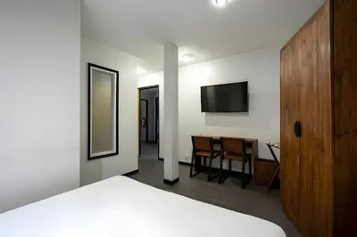 a bedroom with a bed and a table and a television at XX GO INN Sukhumvit Soi 20 - โกอิน สุขุมวิท 20 BTS อโศก in Bang Kapi