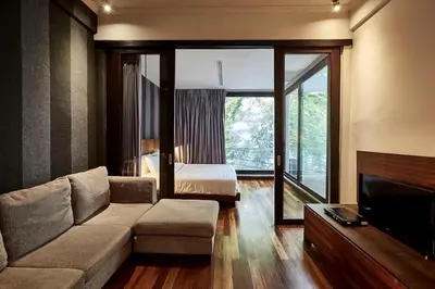 a living room with a couch and a bed at Wish Inn Silom - วิช อินน์ สีลม in Bang Rak